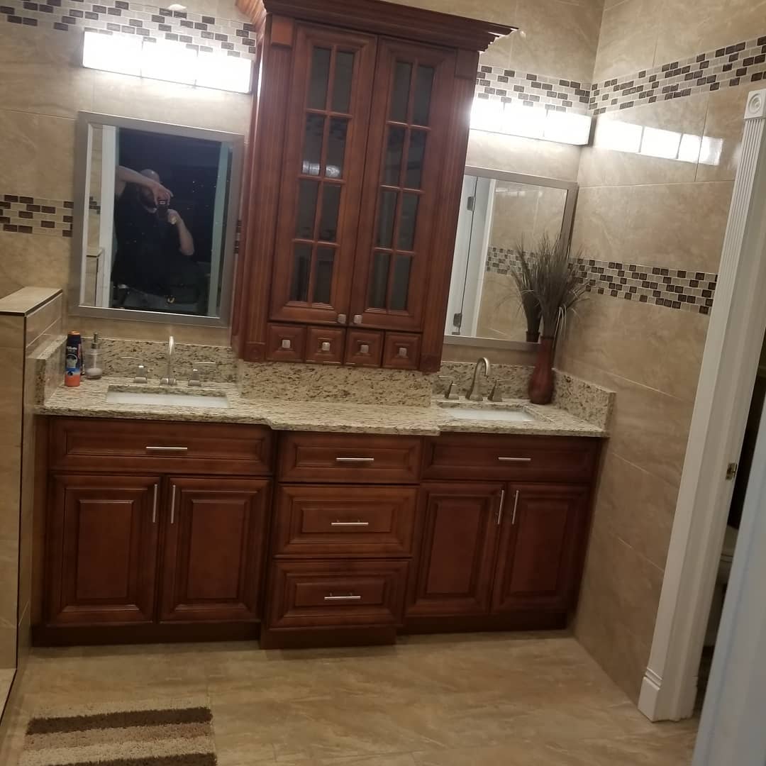 Finished double-vanity bathroom with cherry cabinets, granite and mosaic tile
